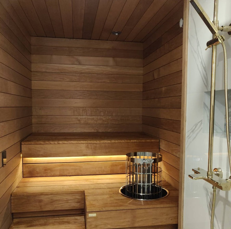 Saunan valaistus LED-ratkaisuilla varustettu moderni sauna, jossa lämmin puupaneeli ja tunnelmallinen valaistus.