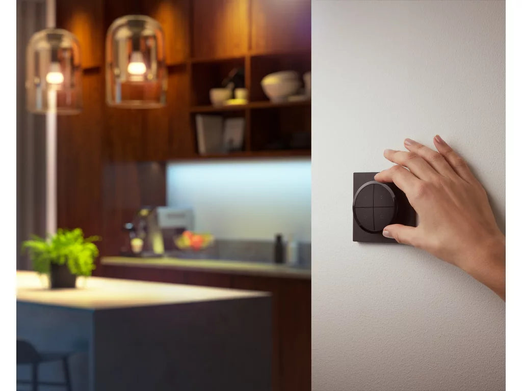 Philips Hue Tap Dial Switch with hand adjusting light settings in a modern kitchen.