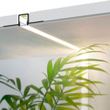 Yksityiskohta PIILO10 TRIMLESS LED-profiilista, joka on upotettu kattopintaan ja valaisee kasveja.